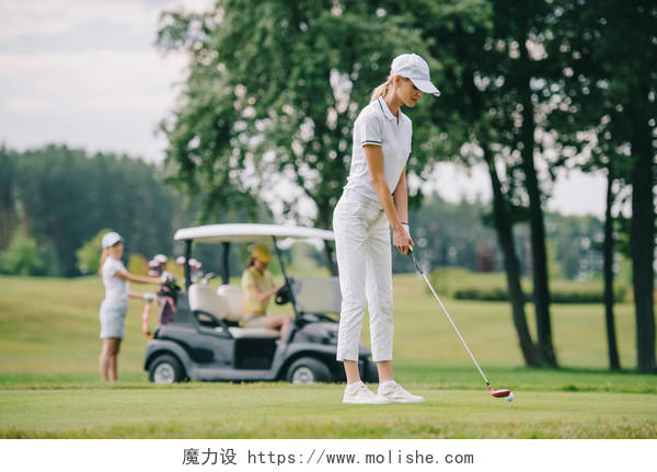 高尔夫球俱乐部妇女的选择焦点高尔夫球场和朋友在绿色草坪上的高尔夫球车休息